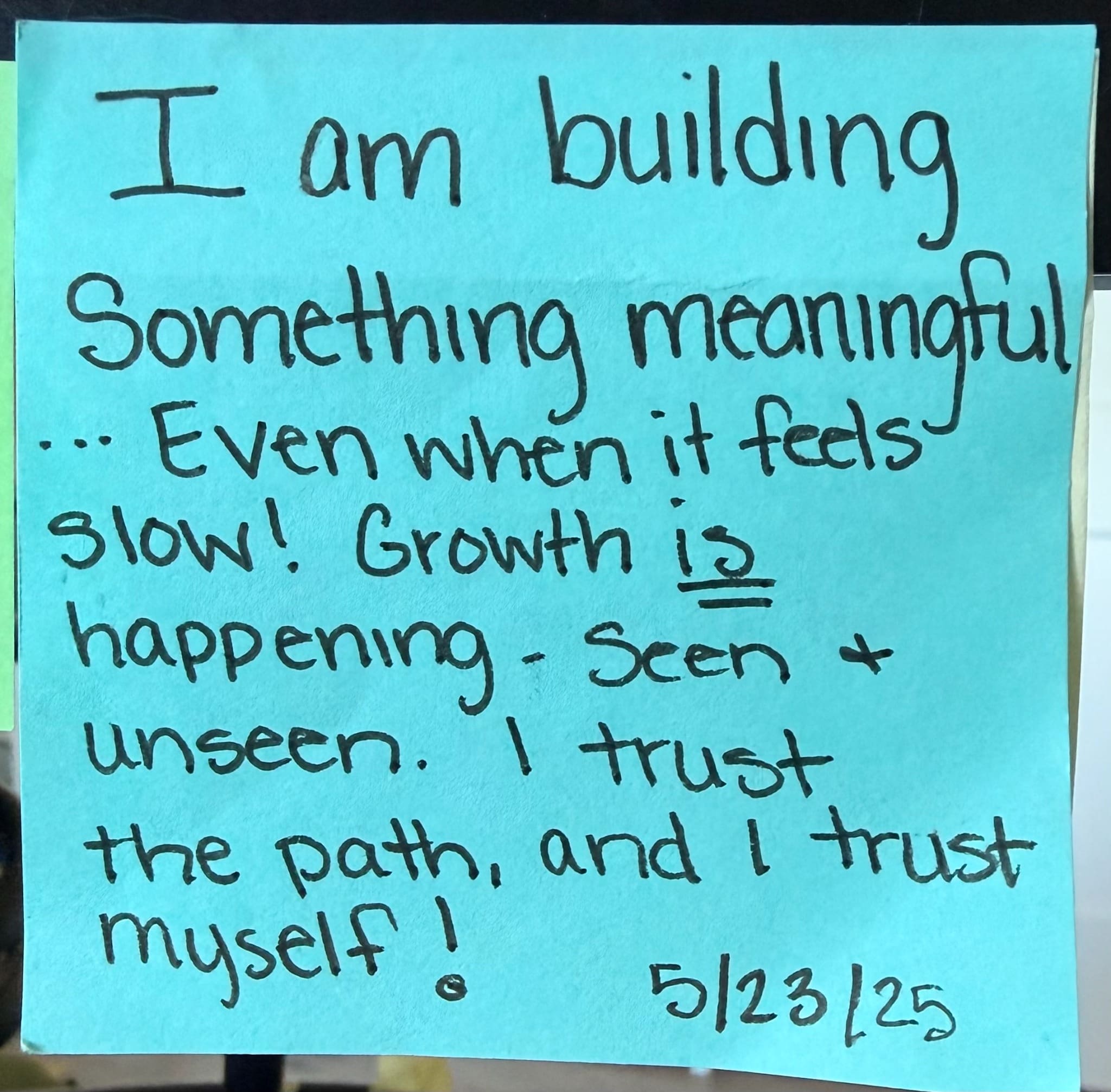 Blue handwritten sticky note dated May 23, 2025 reminding me that I am building something meaningful and growth is happening, seen and unseen.